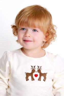 Studio portrait of little girl with red hair and white background.