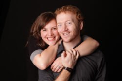 portrait of couple smiling in a studio with black background