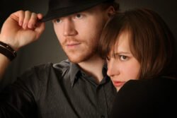 portrait of guy and girl hugging head shot with hand on hat