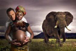 maternity portrait of a pregnant women wearing African clothes with husband hugging her with an elephant behind them